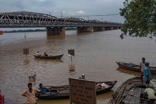 <p>Boatmen stand by the rising water level of the River Yamuna after heavy rainfall in Prayagraj, in the northern Indian state of Uttar Pradesh on Saturday</p>
