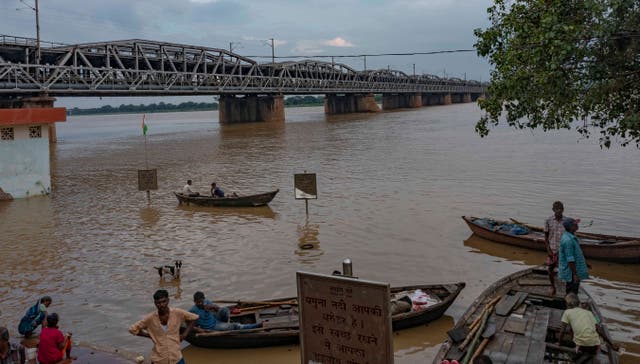 <p>Boatmen stand by the rising water level of the River Yamuna after heavy rainfall in Prayagraj, in the northern Indian state of Uttar Pradesh on Saturday</p>
