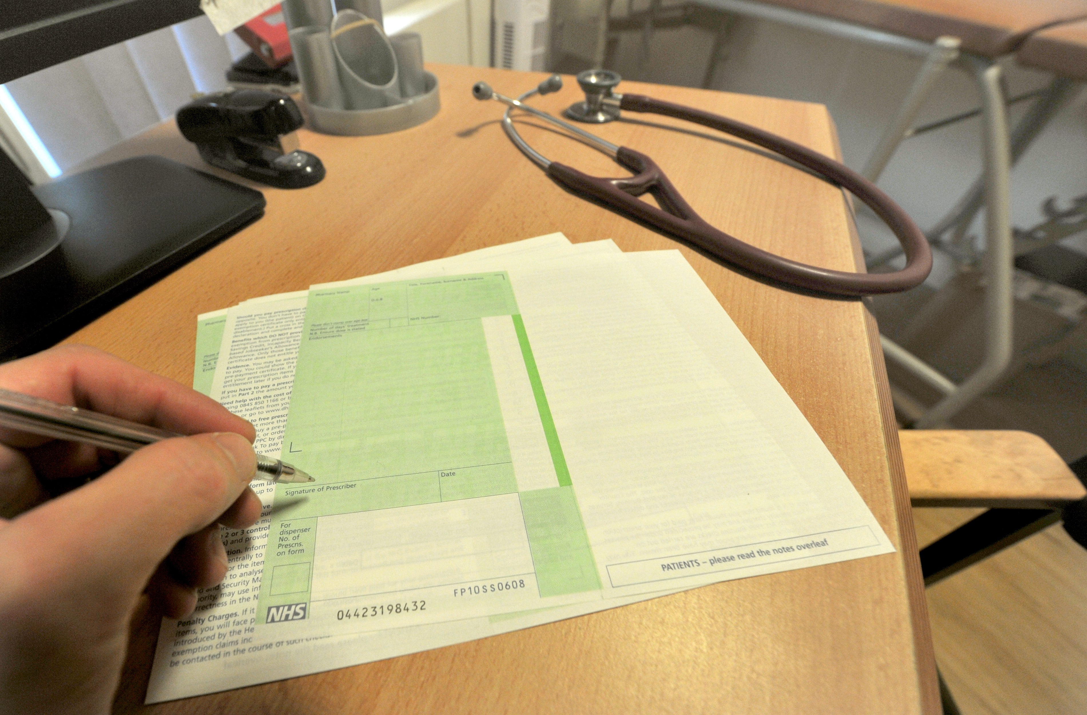A GP writes a prescription in a practice room (Anthony Devlin/PA)