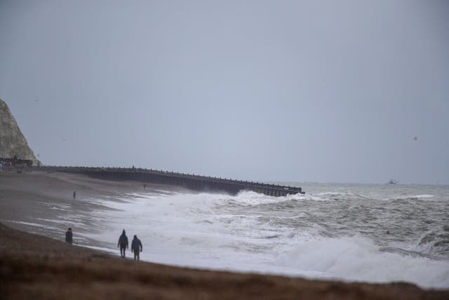 People walk on the beach at Seaford in Sussex (Steve Parsons/PA)