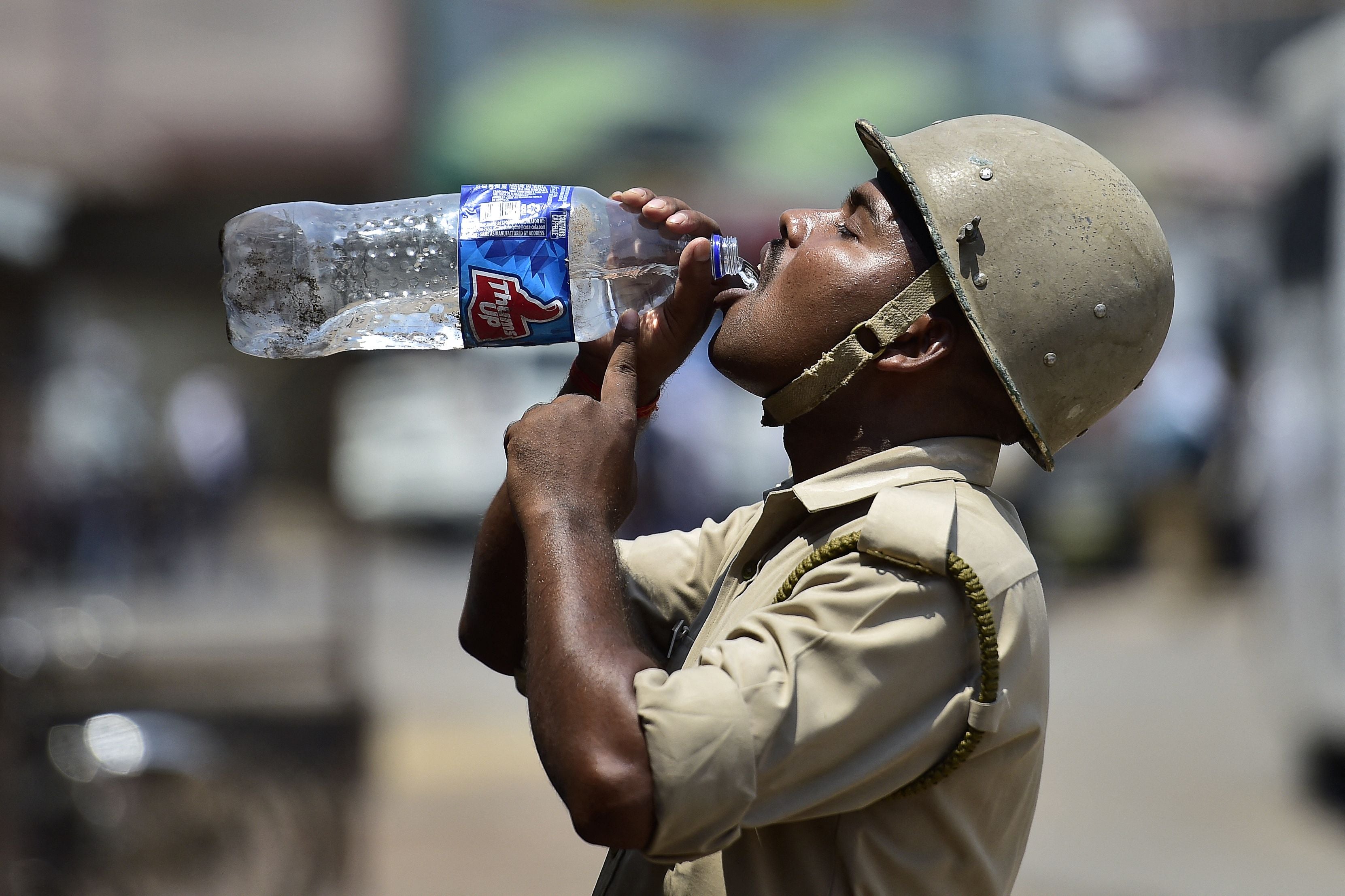 File photo: A policeman drinks water as he stands guard in the Atala area during Friday noon prayer in Allahabad on 17 June