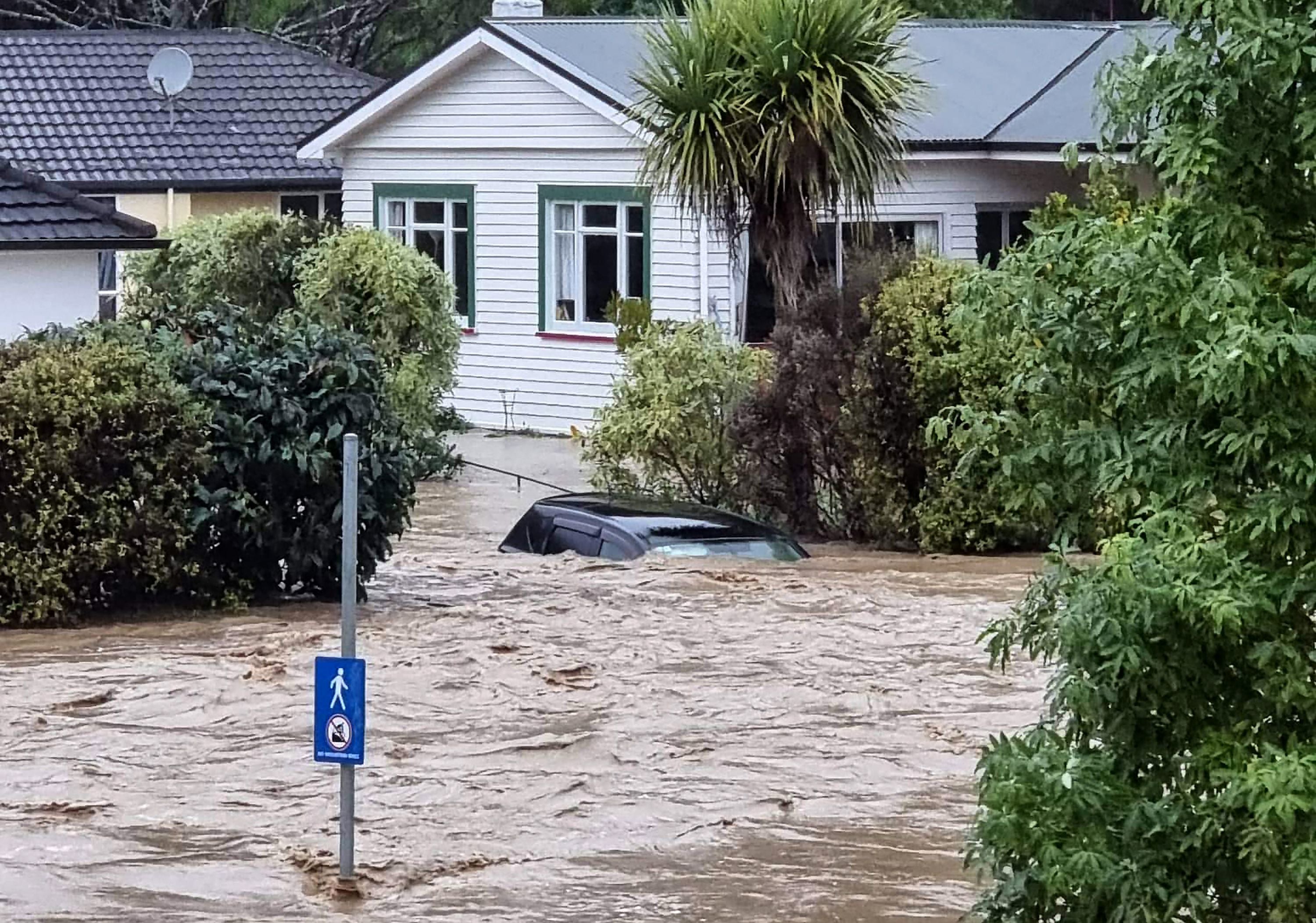 A car is inundated by floodwater in central Nelson, New Zealand
