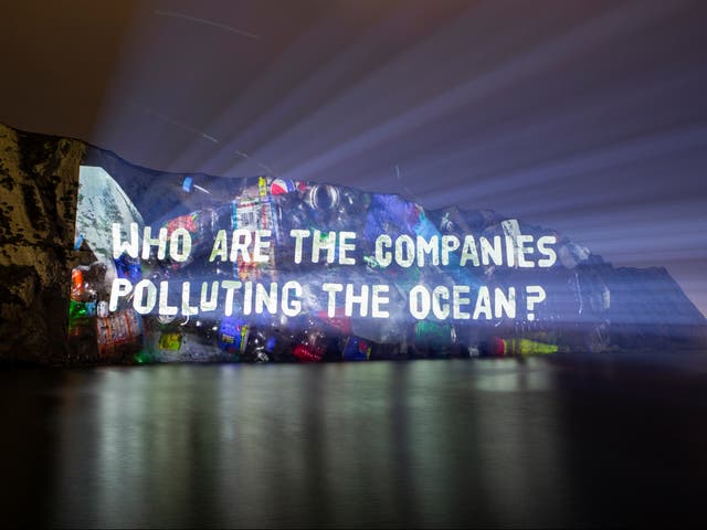 <p>Projection onto the White Cliffs of Dover highlighting the firms behind worsening levels of plastic waste in the environment</p>