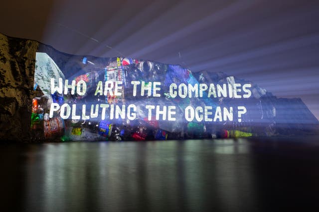 <p>Projection onto the White Cliffs of Dover highlighting the firms behind worsening levels of plastic waste in the environment</p>