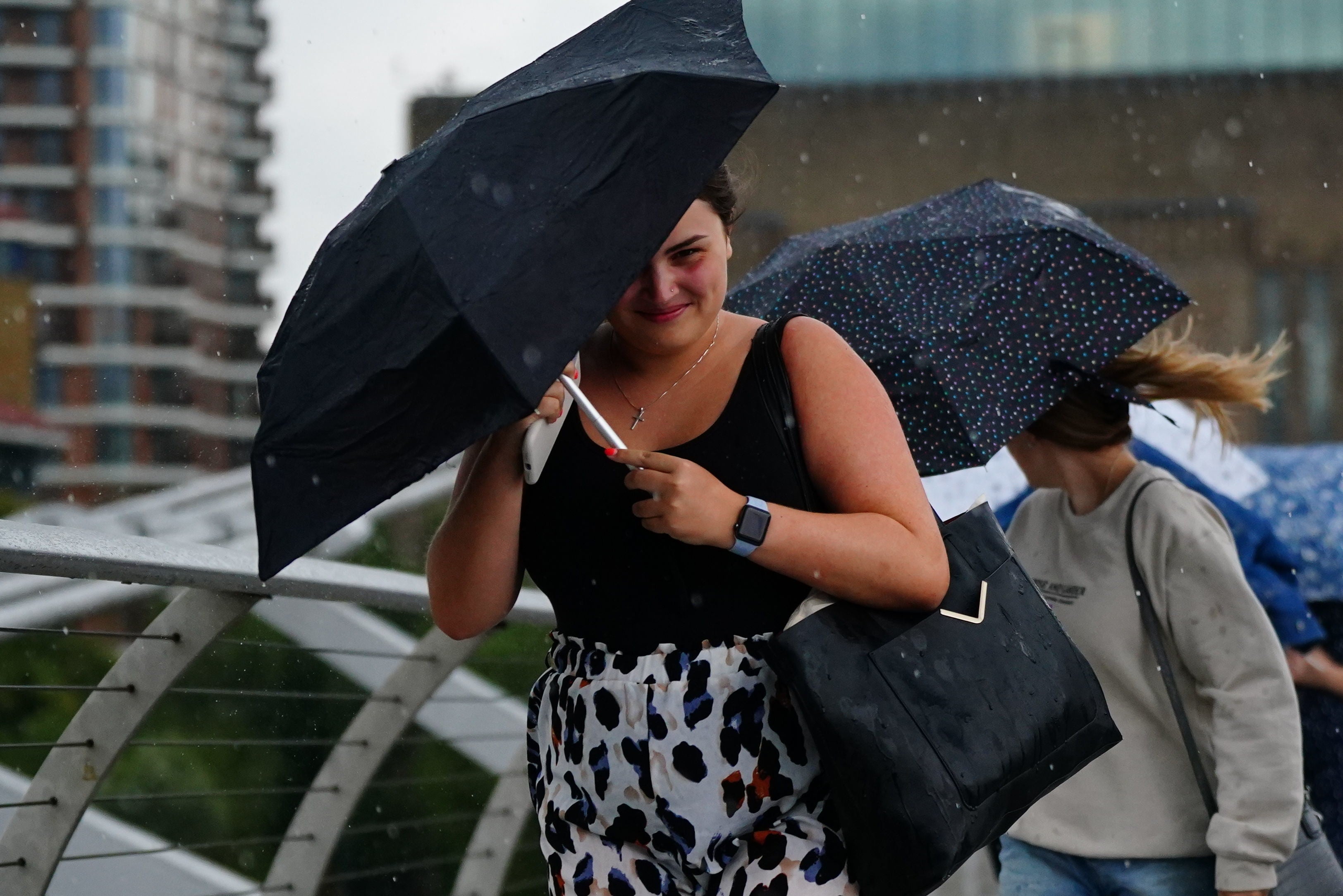 Londoners cross the Thames in heavy rain last week