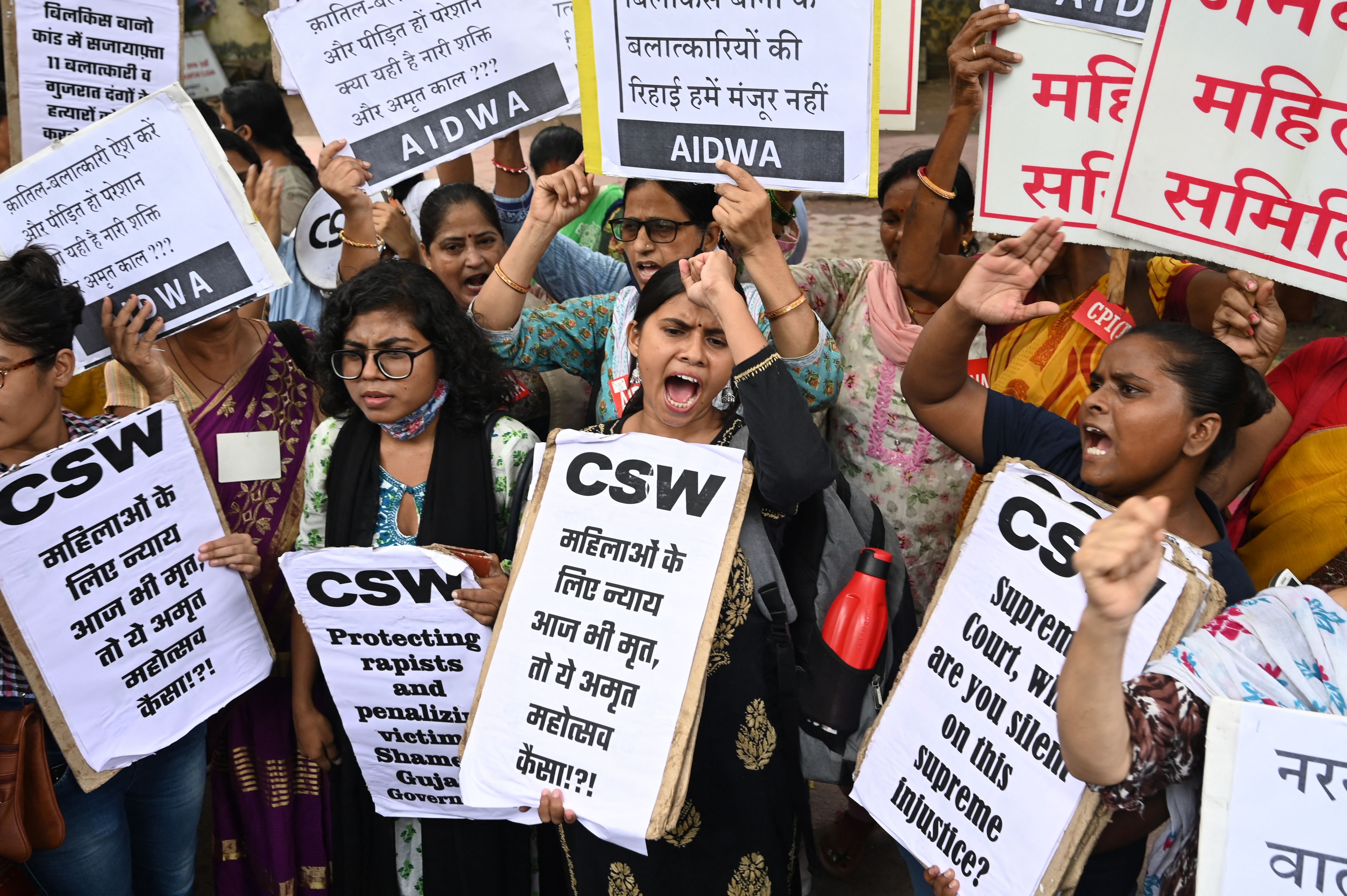 Activists shout slogans and hold placards during a protest against the release, following a recommendation by a Gujarat's state government panel