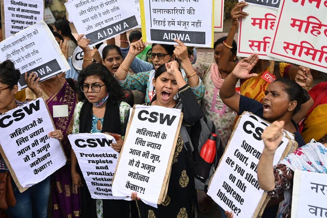 <p>Activists shout slogans and hold placards during a protest against the release, following a recommendation by a Gujarat's state government panel</p>