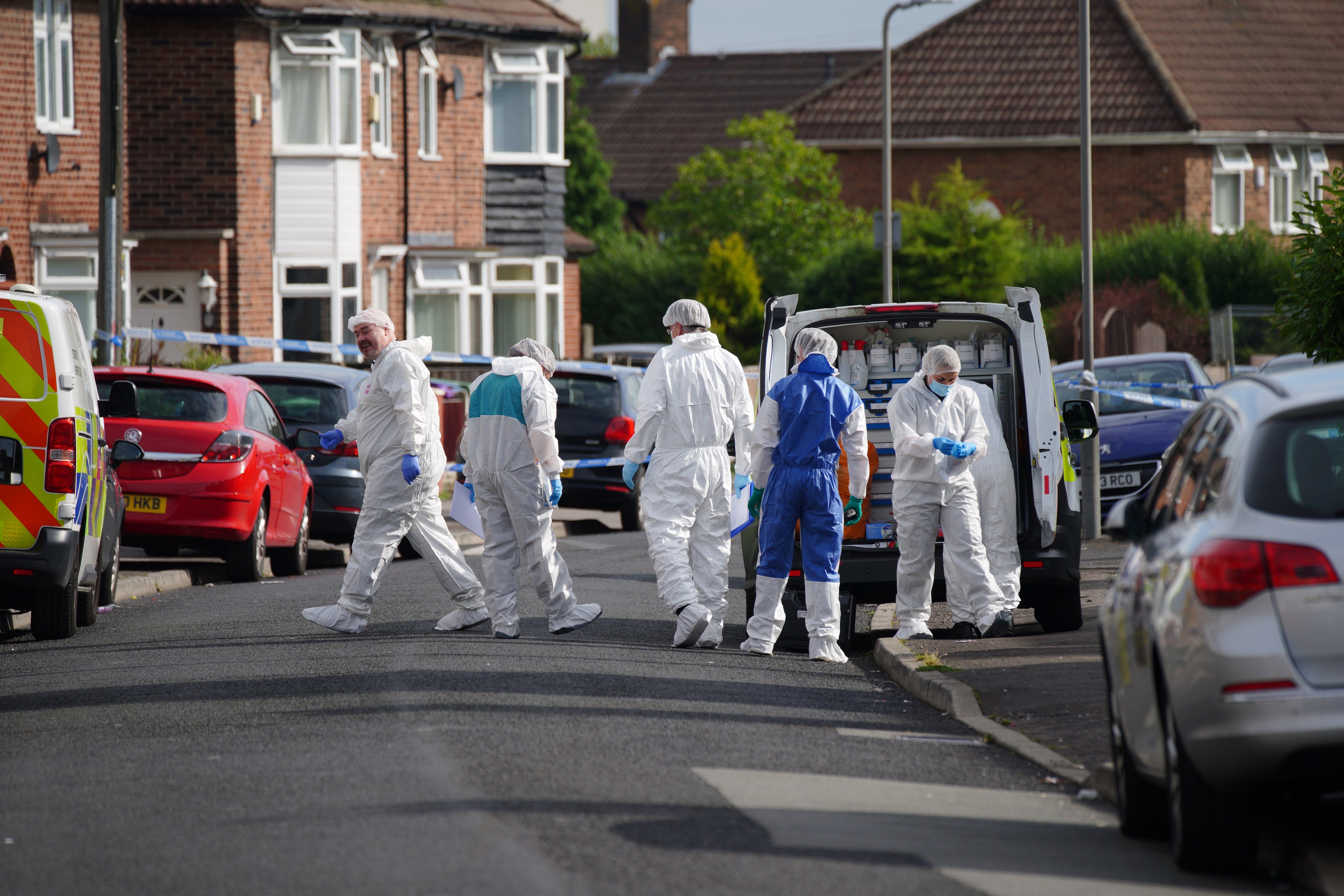 Forensic officers near to the scene in Kingsheath Avenue, Knotty Ash, Liverpool, where a nine-year-old girl has been fatally shot