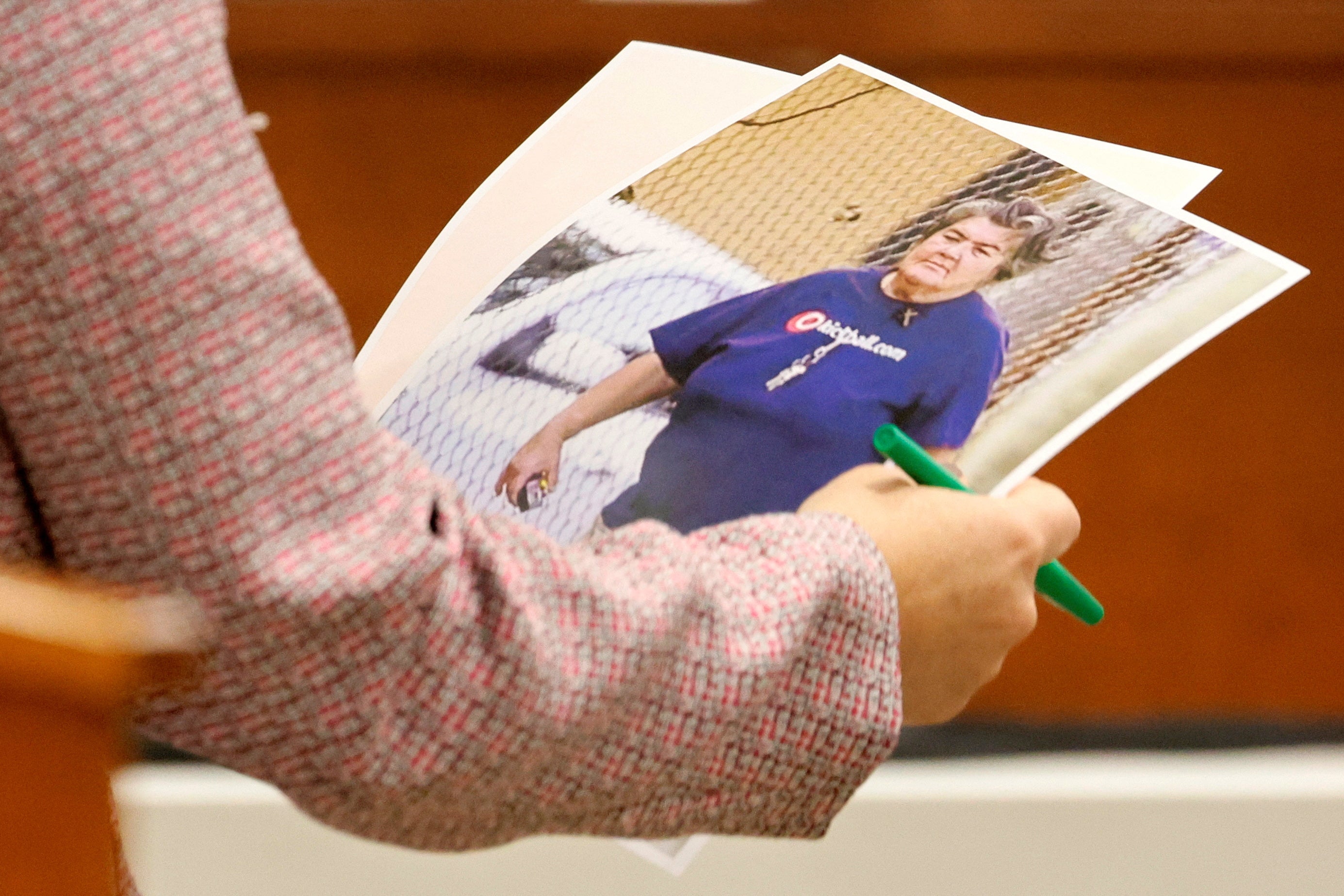 Assistant Public Defender Tamara Curtis carries photographs of Brenda Woodard in court on Monday