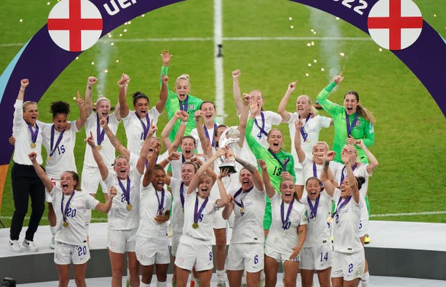 England’s Leah Williamson and Millie Bright lift the trophy (Joe Giddens/PA)
