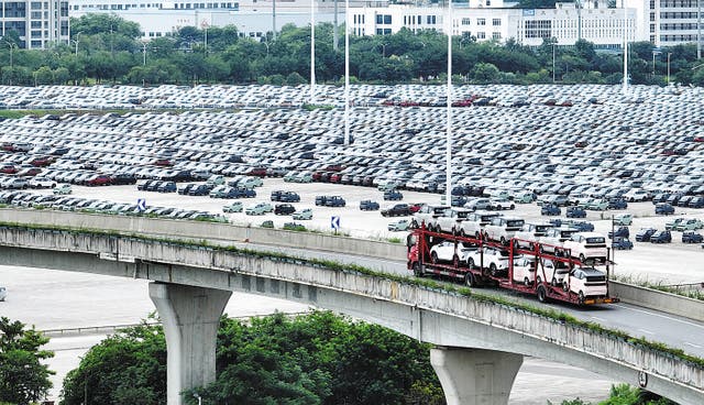 <p>A truck loaded with new energy vehicles passes a logistics base in Liuzhou, Guangxi Zhuang autonomous region, on July 6 </p>