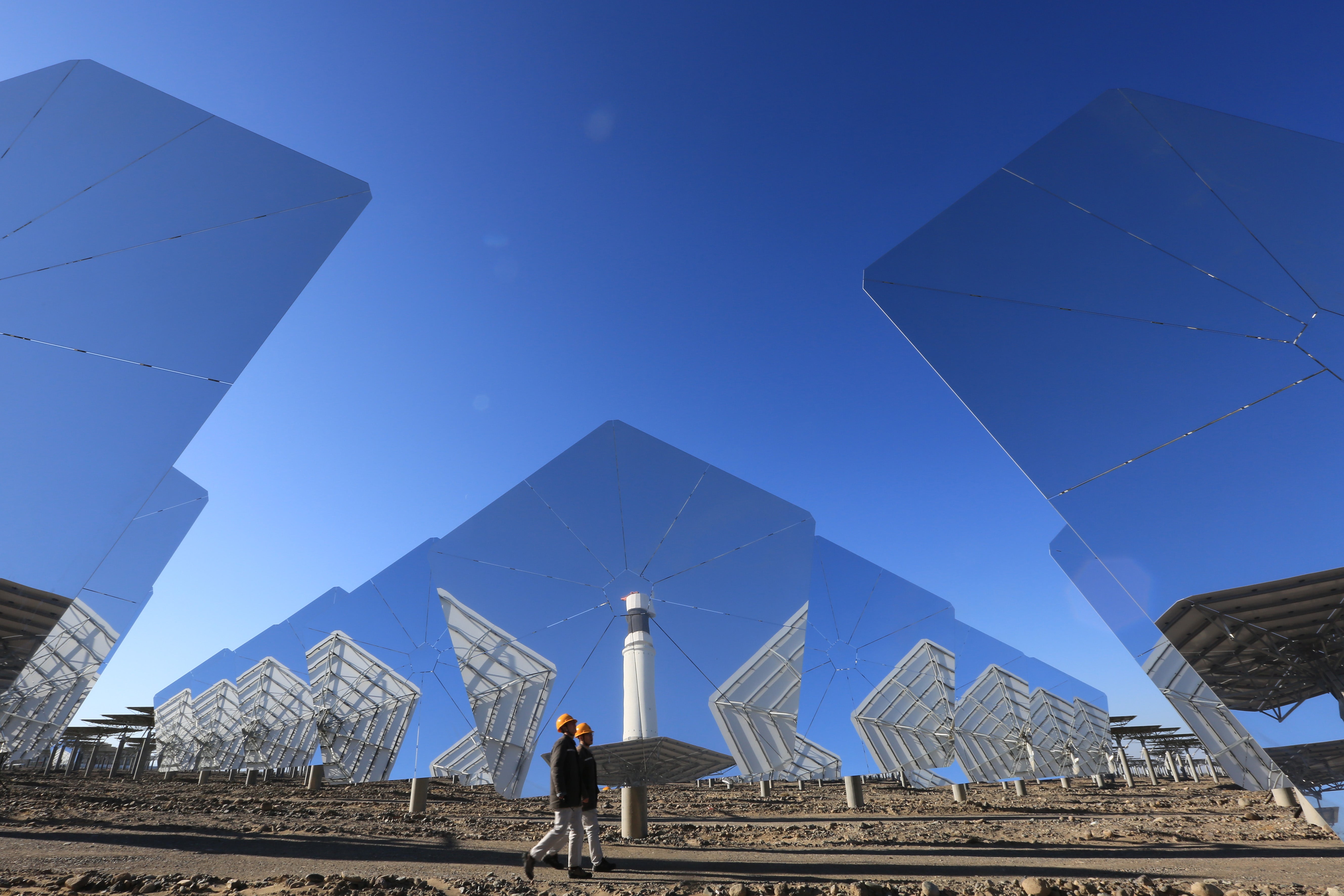 Workers inspect a solar thermal power station in Hami, Xinjiang Uygur autonomous region, in November 2021