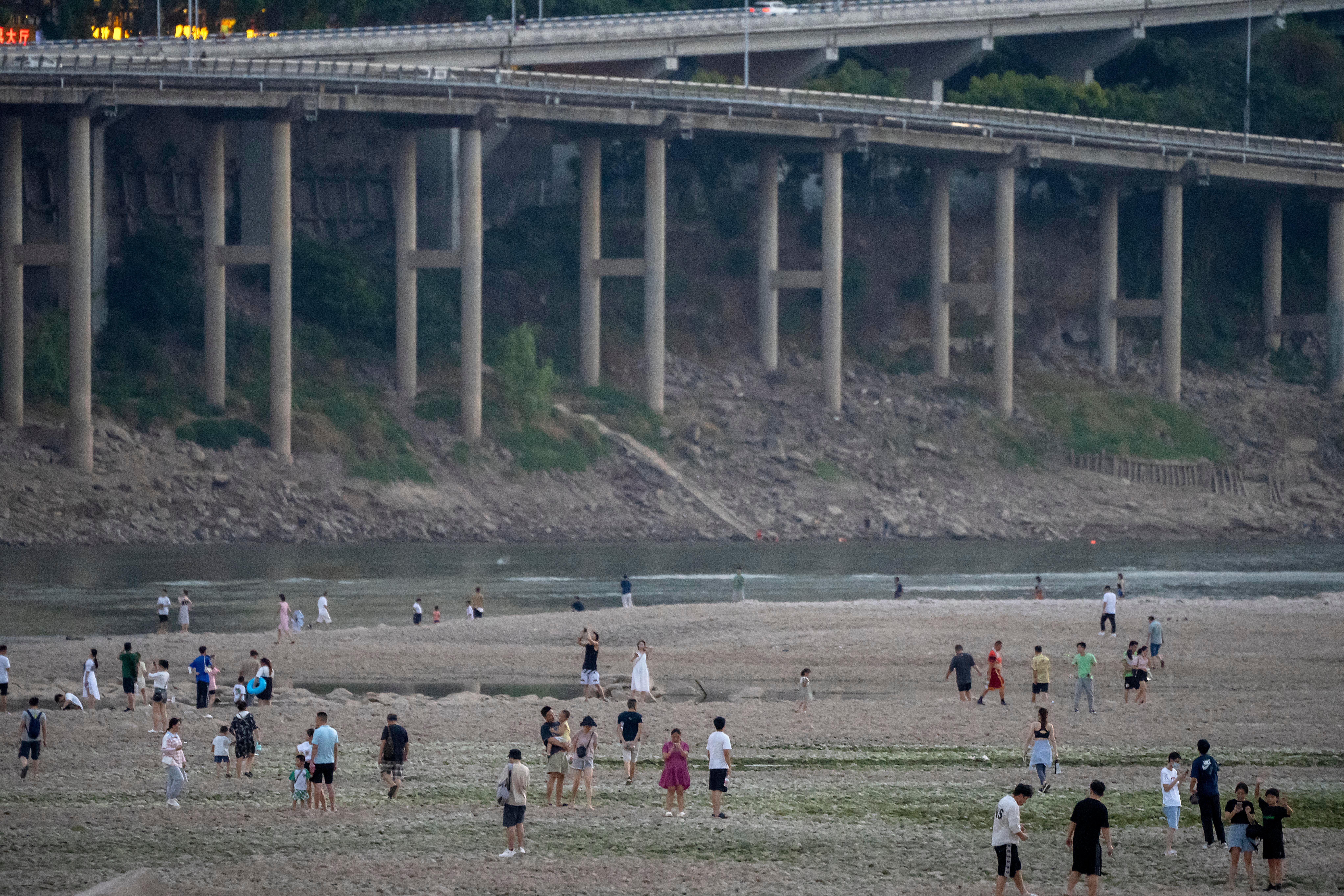 People walk along the dry riverbed of the Jialing River, a tributary of the Yangtze, in Chongqing municipality on 20 August. The very landscape of Chongqing, has been transformed by China’s worst heat wave since modern record-keeping began