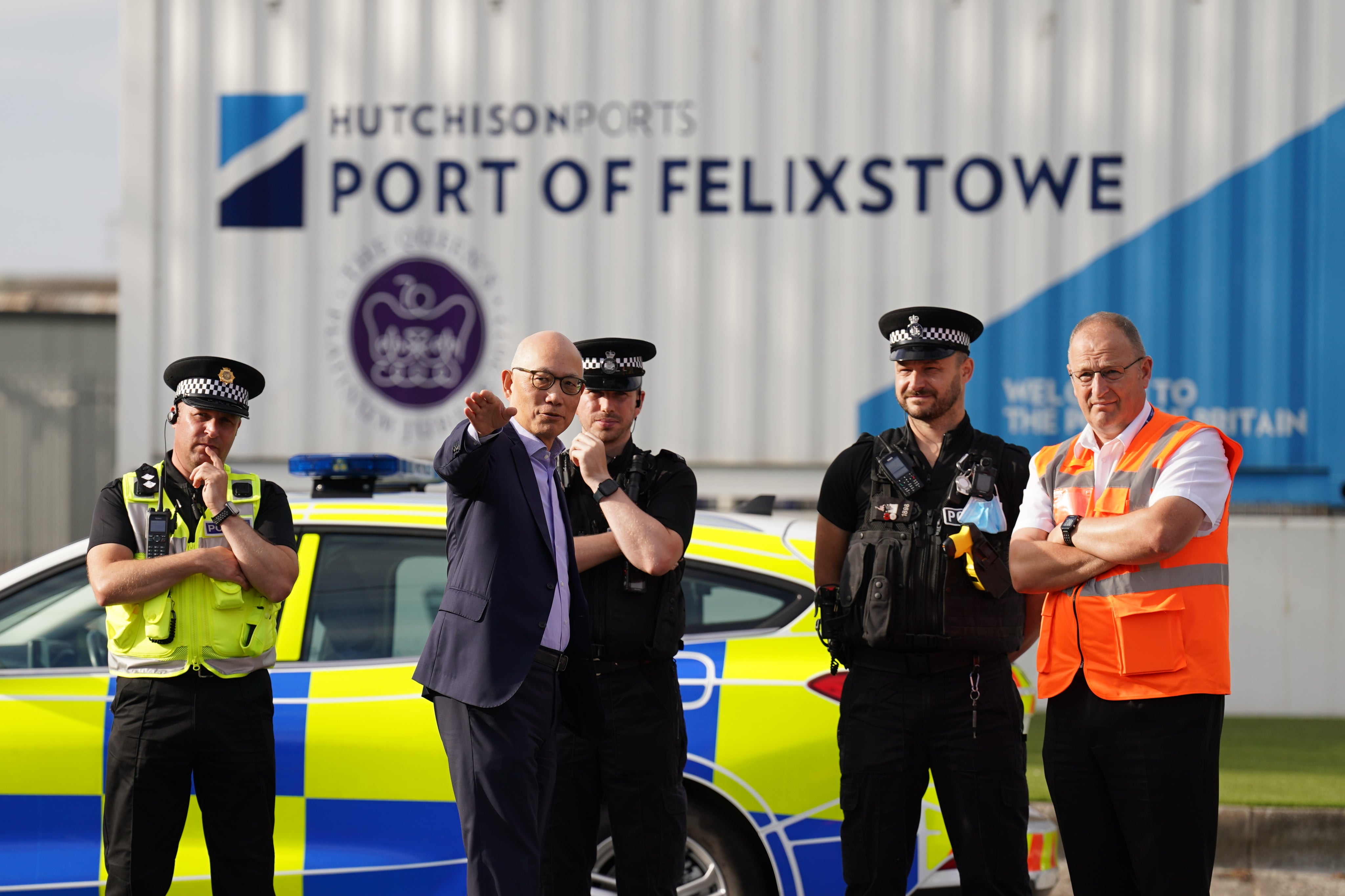 Hutchison Ports chief executive Clemence Cheng and police officers watch members of the Unite union man a picket line at one of the entrances to the Port of Felixstowe (Joe Giddens/PA)