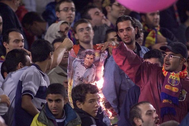 <p>Barcelona fans burning a picture of Luis Figo after his move to Real Madrid in 2000</p>