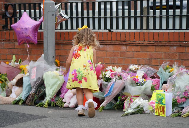 <p>A young girl lays a tribute in Kingsheath Avenue, Liverpool, where nine-year-old Olivia Pratt-Korbel was fatally shot on Monday night (Peter Byrne/PA)</p>