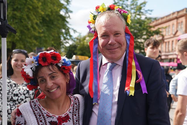 Conor Burns (left), Minister of State for Northern Ireland speaks with Marina Furey from Znamjanka, as he joins Ukrainians celebrating Ukraine independence Day, outside Belfast City Hall (Niall Carson/PA)