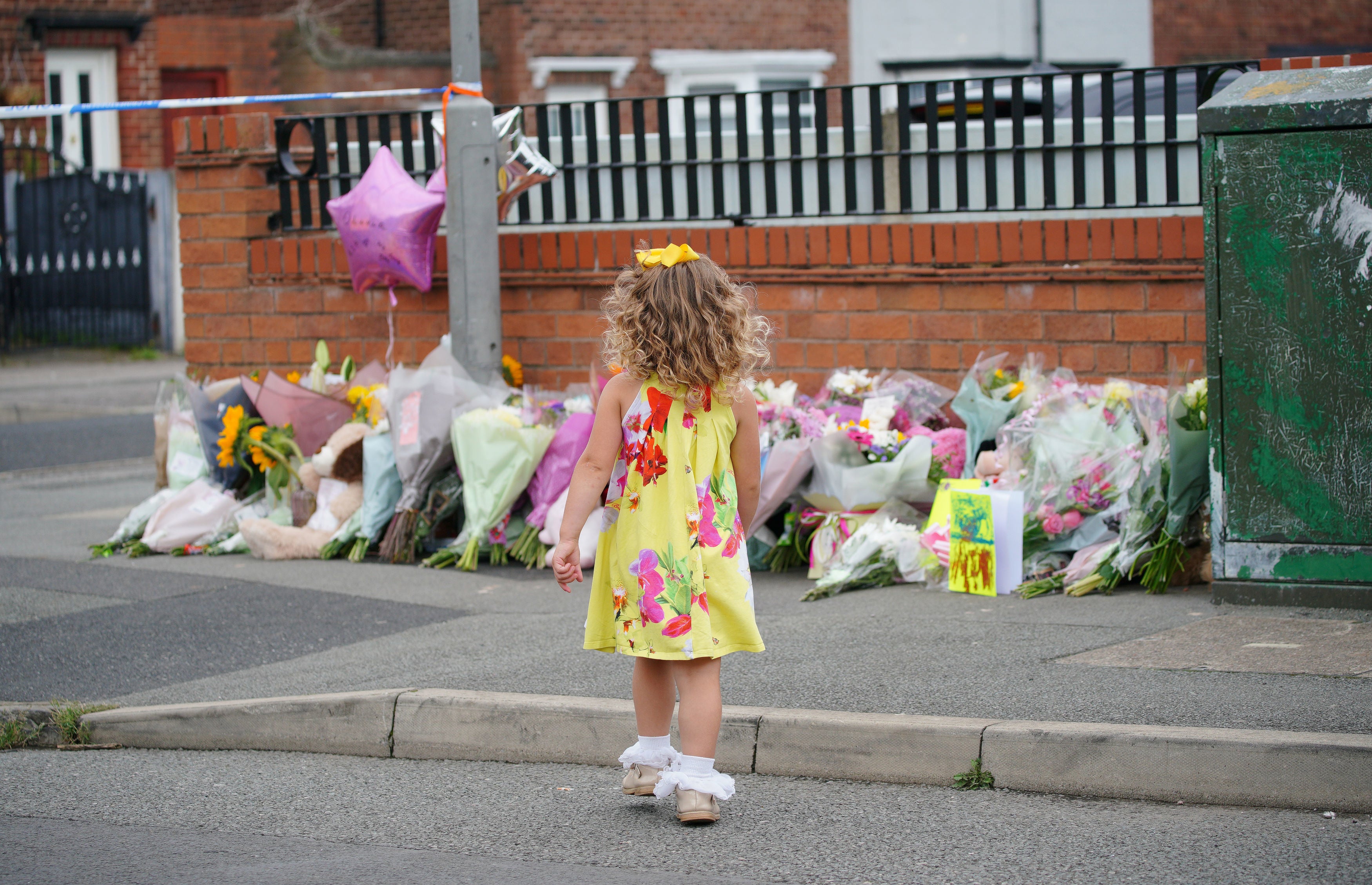 A young girl lays a tribute in Kingsheath Avenue, Knotty Ash, Liverpool, where nine-year-old Olivia Pratt-Korbel was fatally shot on Monday night