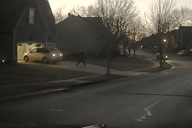 <p>Dash cam video footage from 20 January 2018 included in the Washington Post’s visual investigation shows Officer Clayton Jenisen approaching the minivan driven by 17-year-old John Albers with his weapon drawn</p>