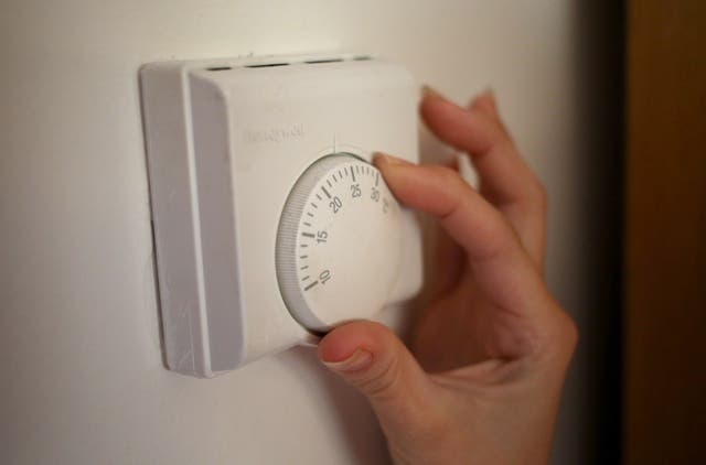 A person using a central heating thermostat (Steve Parsons/PA)