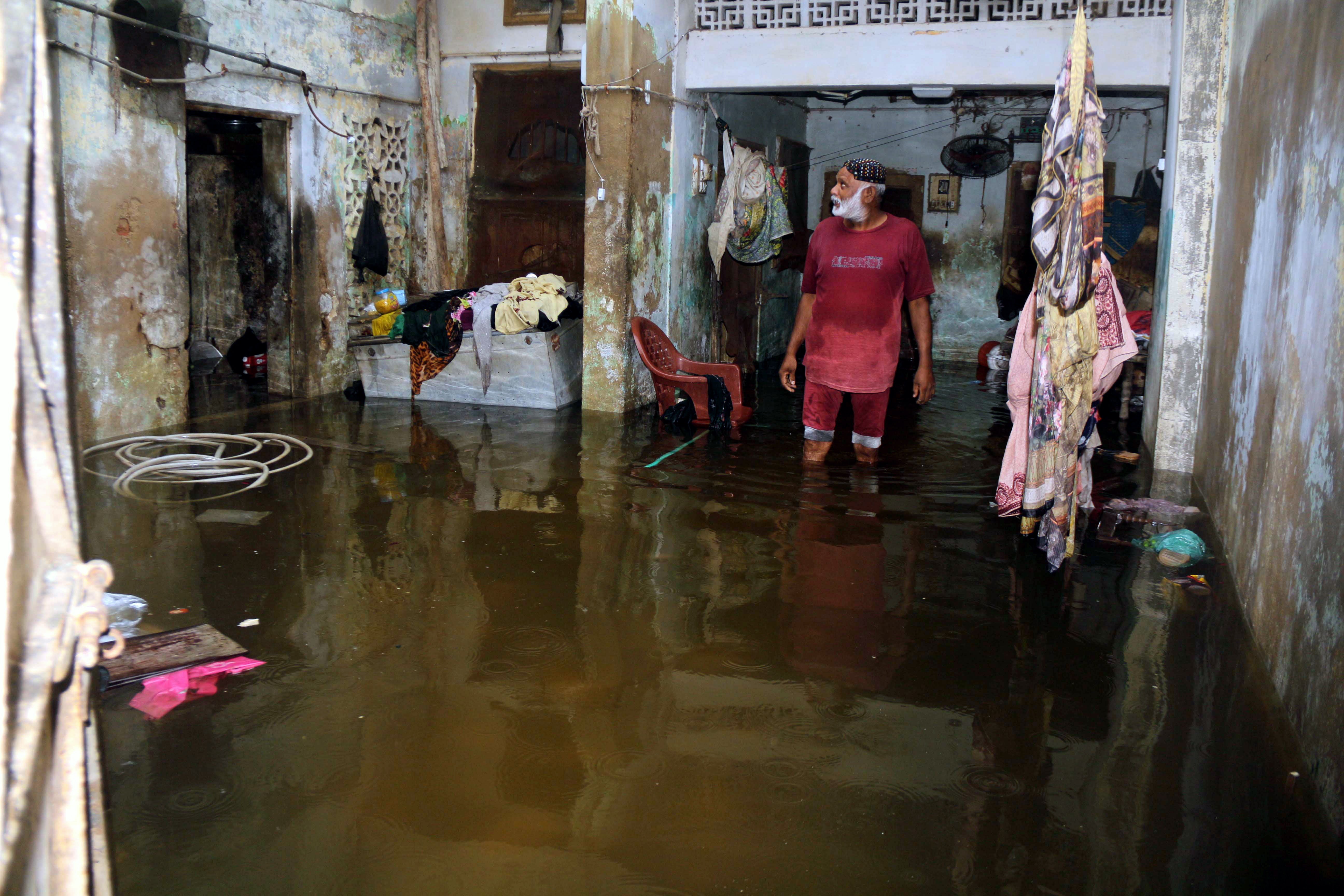 A man stands in his flooded house after heavy rains in Hyderabad, Pakistan