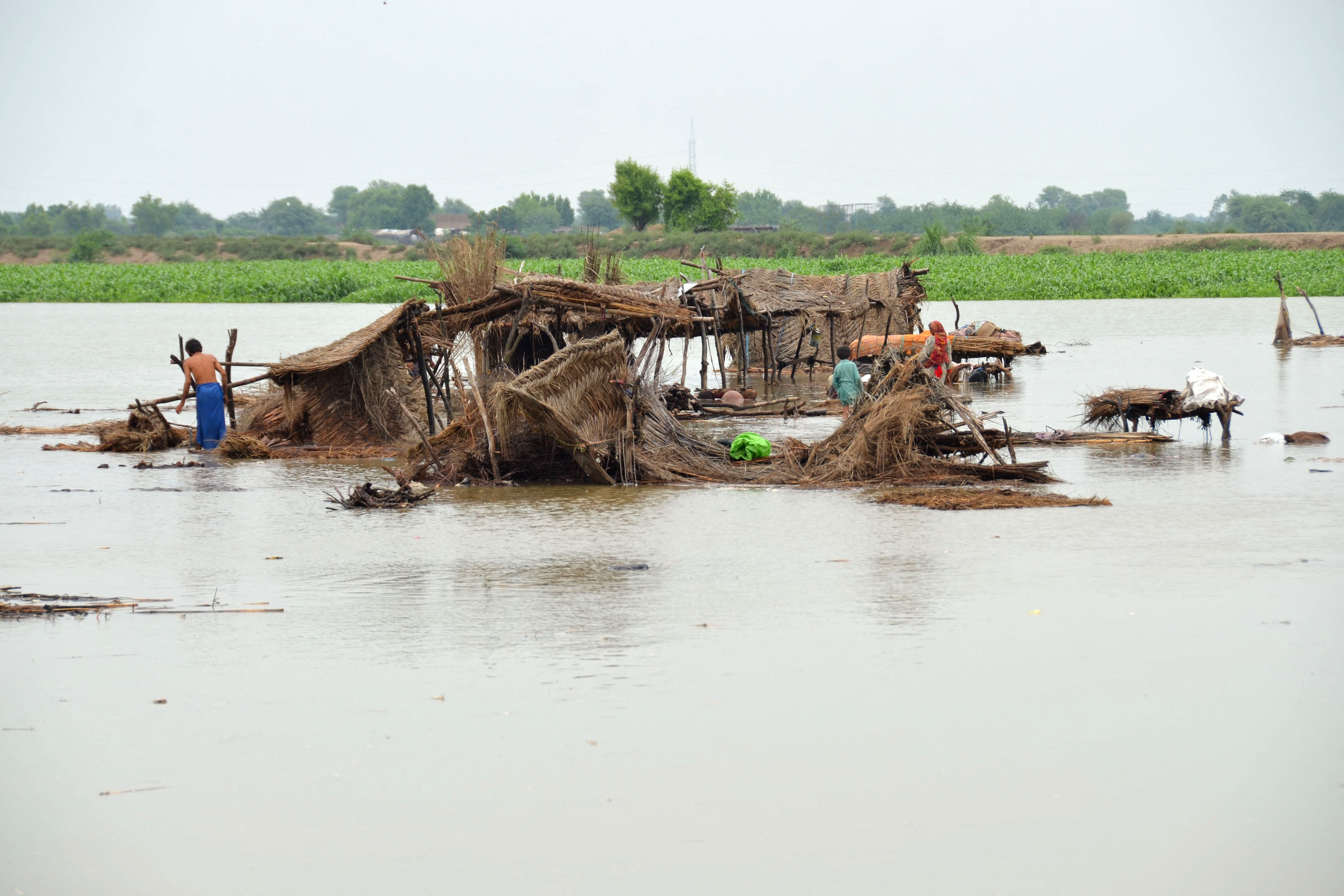 Villagers search for their belongings after their huts were destroyed in flood waters in Jaffarabad district of Balochistan province