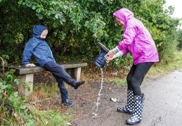 Mia West, aged 11, and Jack West, aged 7 with soggy wellies at Ingrebourne Valley Nature Reserve in Rainham (Ian West/PA)