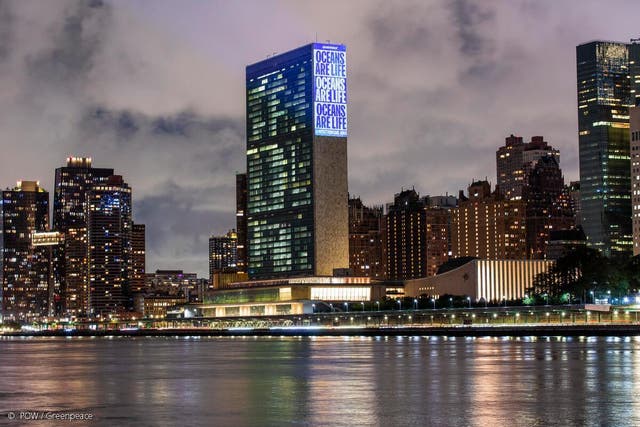 <p>Greenpeace activists project messages calling for ocean protection on to the UN headquarters in New York</p>