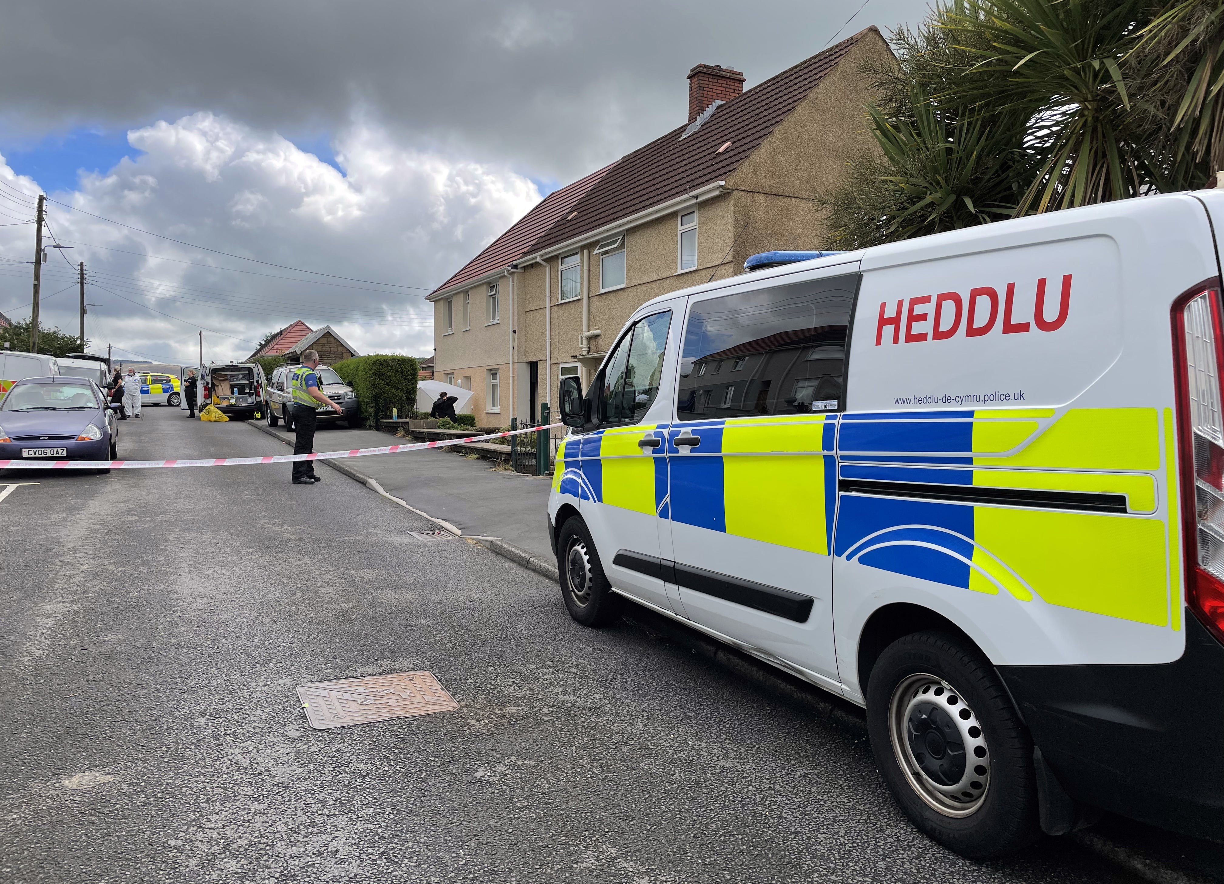South Wales Police and forensic units at the scene where a 71-year-old woman was murdered outside her home on Tanycoed, Clydach, Swansea. Picture date: Wednesday August 24, 2022.