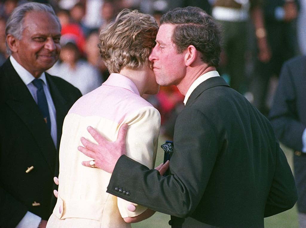The Prince of Wales tries to kiss his wife after leading his team to victory at the Jaipur Polo Club during a tour of India in 1992 (Martin Keene/PA)