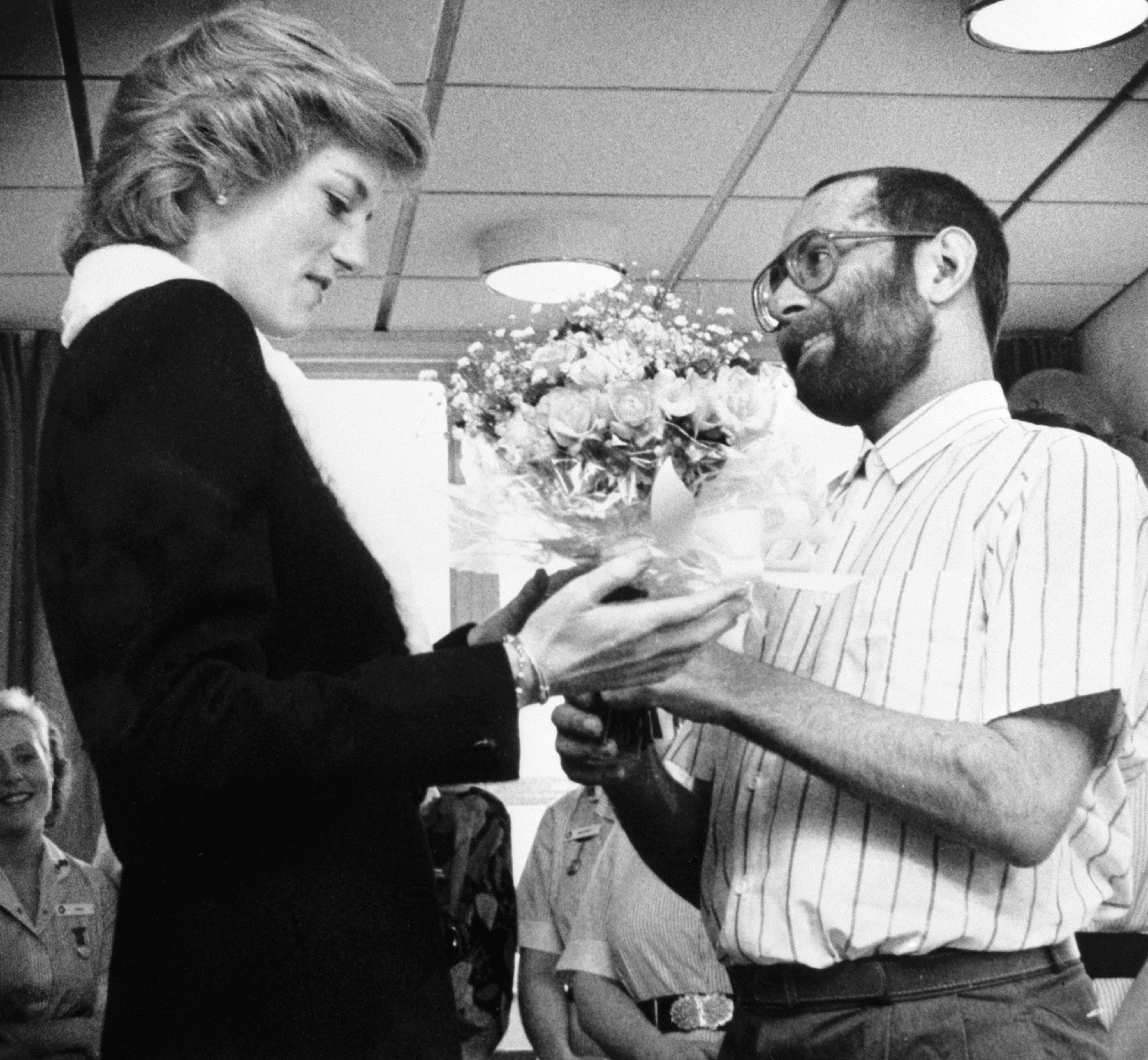 The Princess of Wales is presented with a bouquet by patient Martin Johnson during her visit to the Mildmay Mission Hospital Aids Hospice in East London in 1989 (PA)