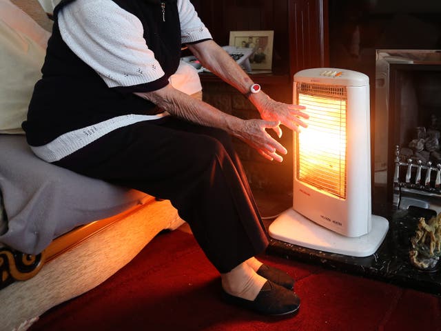 An elderly lady with her electric fire on at home (PA)