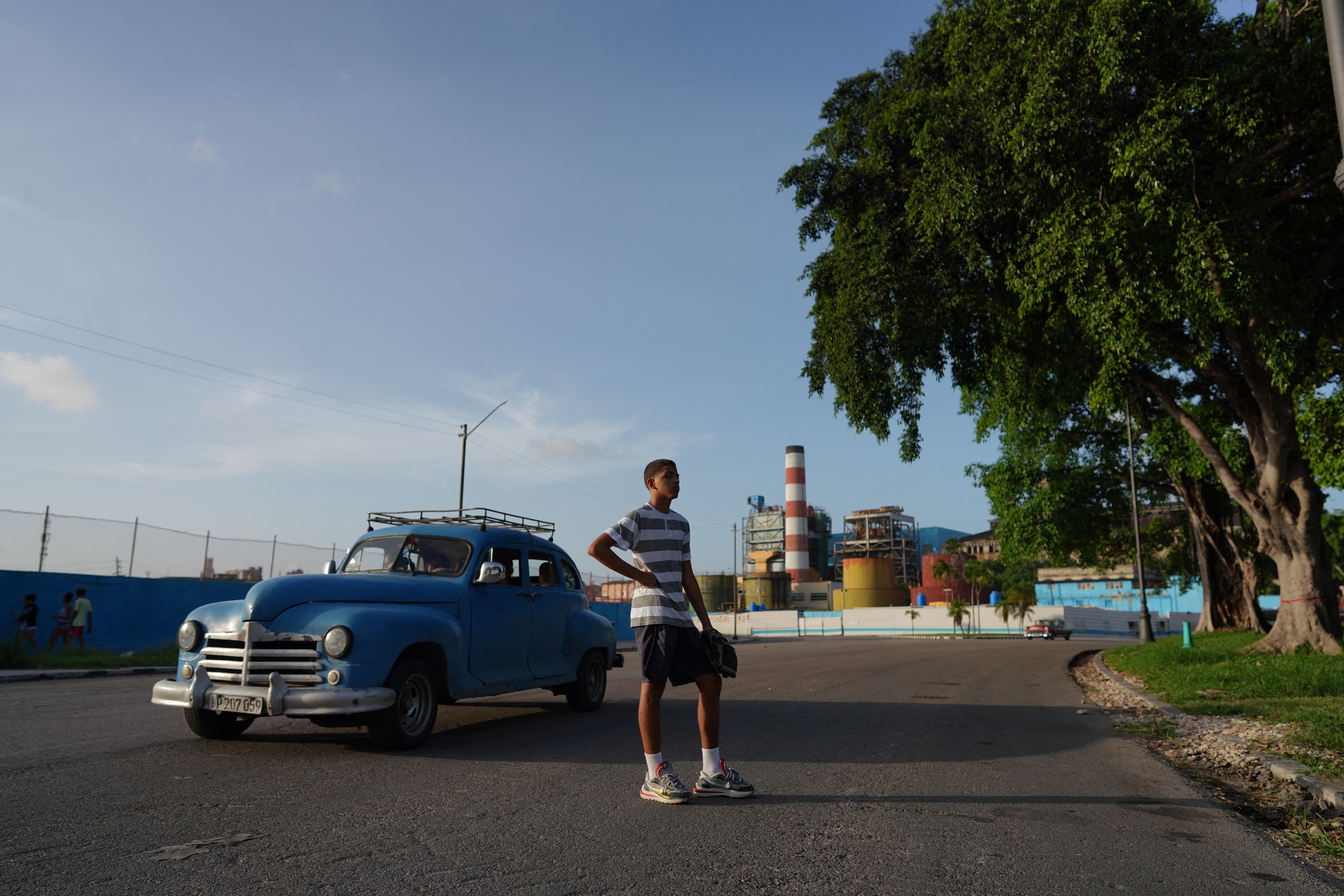 A teenager plays baseball at a park in Havana