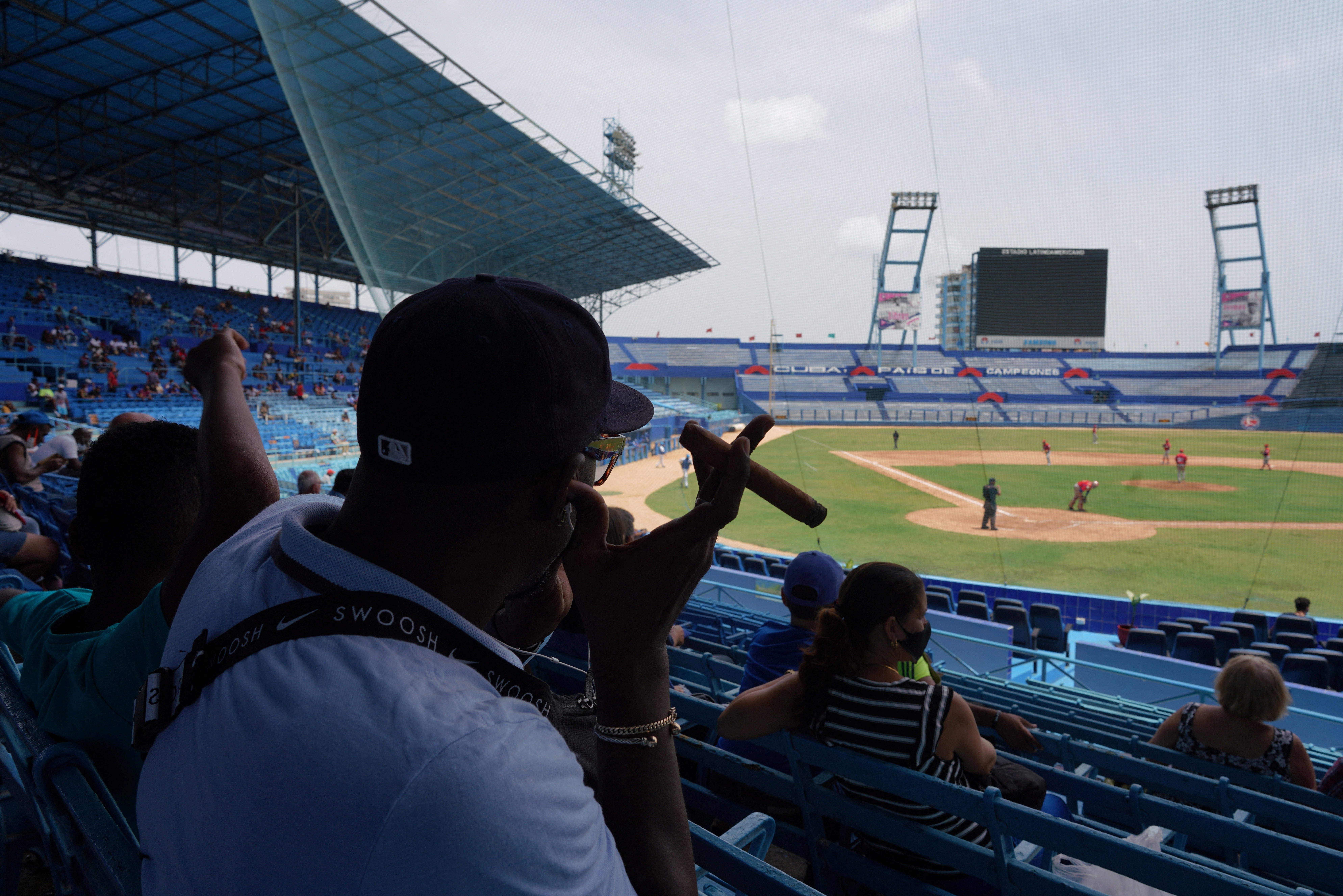 A baseball fan smokes a cigar during the match