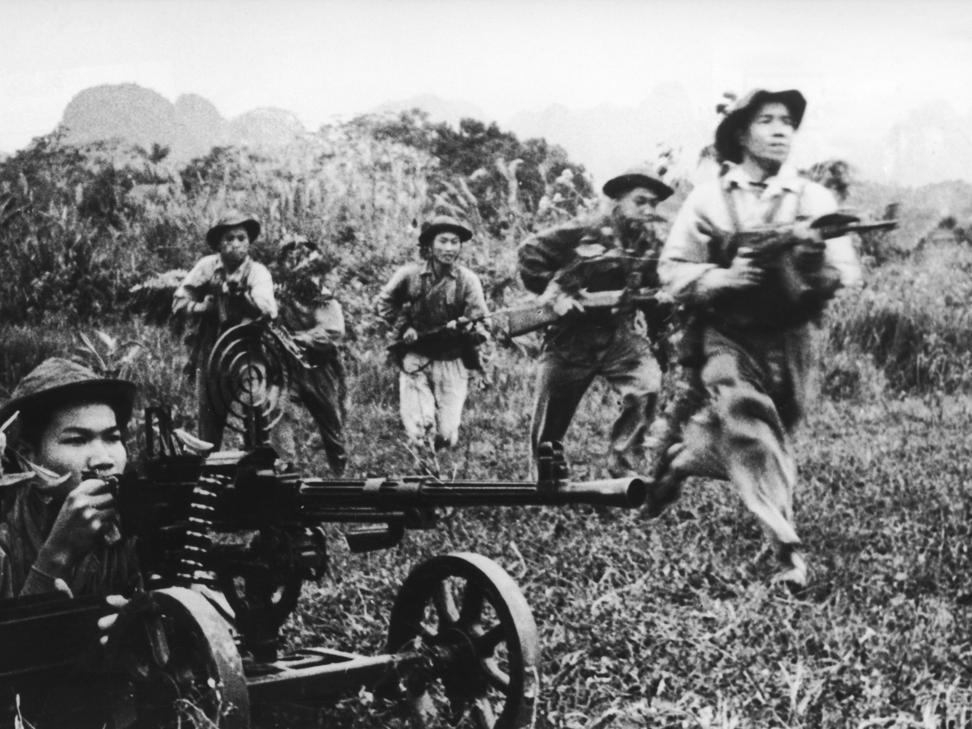 A Viet Cong soldier (far right) carries an AK-47 into an attack