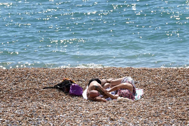 People enjoy the warm weather on the beach in St Leonards, Sussex (Gareth Fuller/PA)