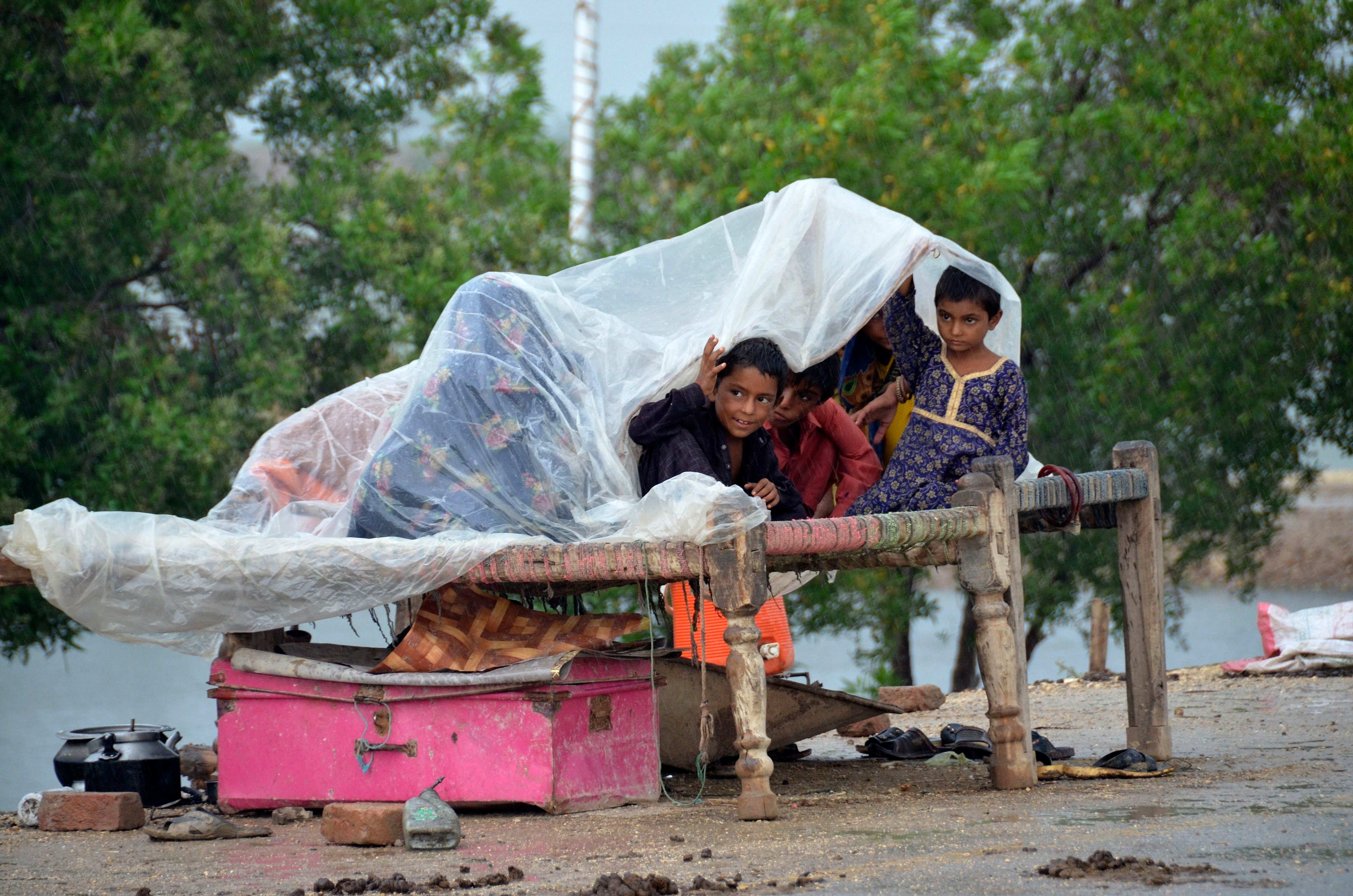 A displaced family takes refuge on a roadside after fleeing their flood-hit home in Jaffarabad, Baluchistan province, on Wednesday