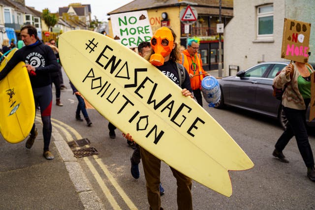 <p>Campaigners march from Fistral Beach, Newquay, as they take part in a National Day of Action on Sewage Pollution</p>