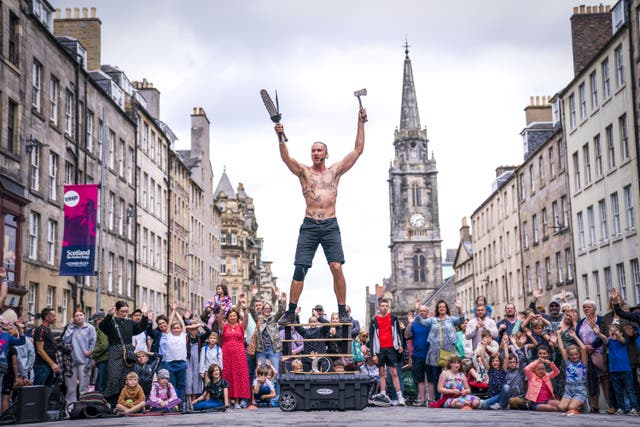 Circus street artist Reidiculous performs for the crowds on the Royal Mile, Edinburgh, ahead of this year’s Edinburgh Festival Fringe (Jane Barlow/PA)