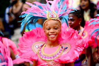 Youths in colourful costumes proceed down Ladbroke Grove