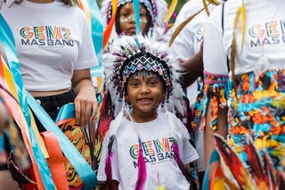 A young performer in a colourful costume takes part in Children