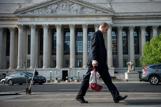 <p>A man walks past the US National Archives and Records Administration headquarters in Washington, DC</p>