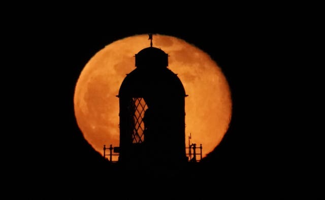 <p>The moon rising at the top of St Mary’s Lighthouse in Whitley Bay, Northumberland (Owen Humphreys/PA)</p>