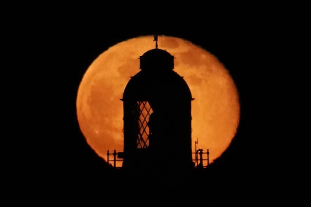 <p>The moon rising at the top of St Mary’s Lighthouse in Whitley Bay, Northumberland (Owen Humphreys/PA)</p>