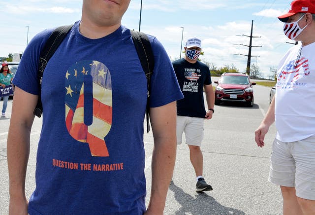 <p>A man wears a QAnon T-shirt in New Hampshire in August 2020</p>