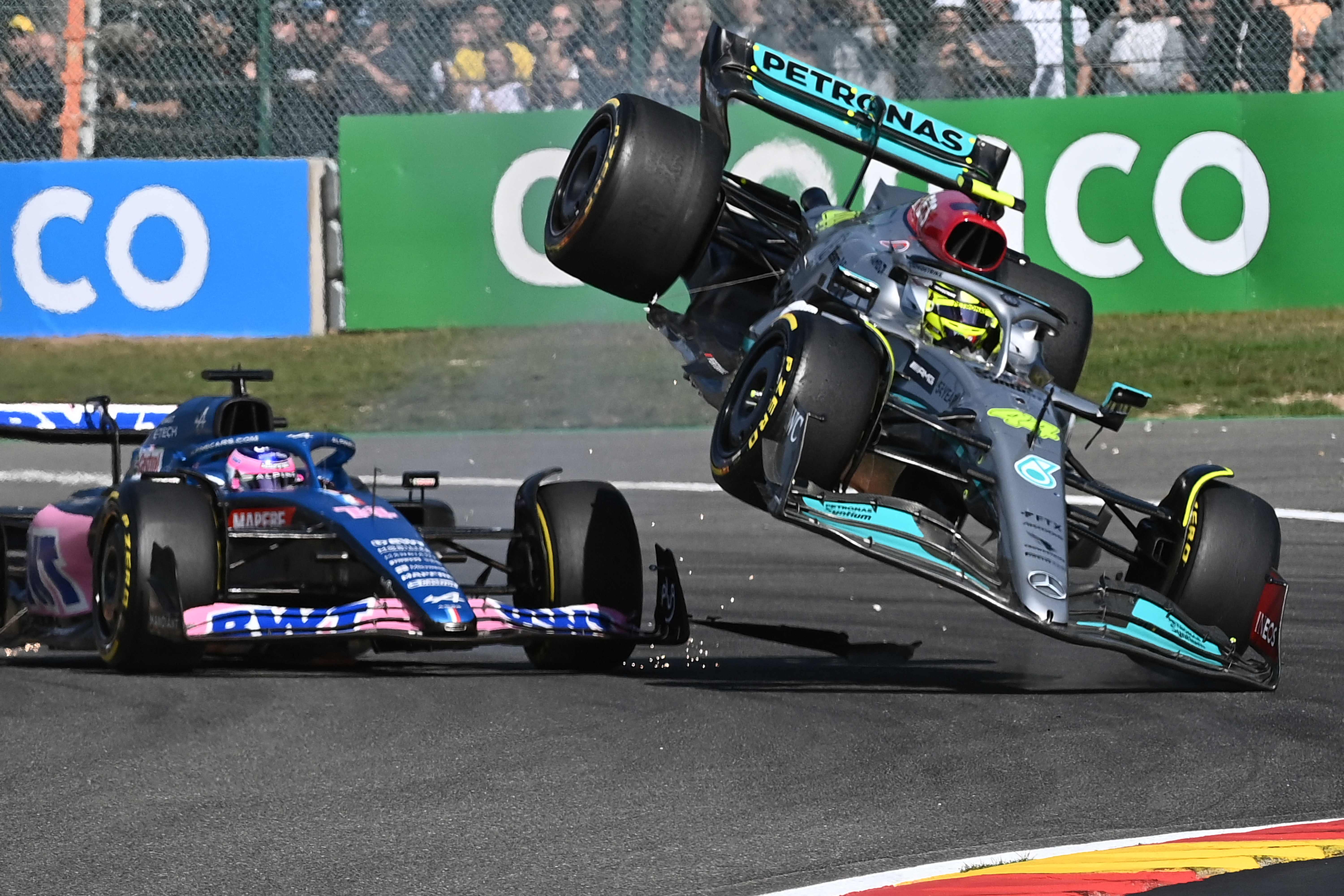 Mercedes' British driver Lewis Hamilton (R) collides with Alpine's Spanish driver Fernando Alonso (C) during the Belgian Formula One Grand Prix at Spa-Francophones racetrack at Spa