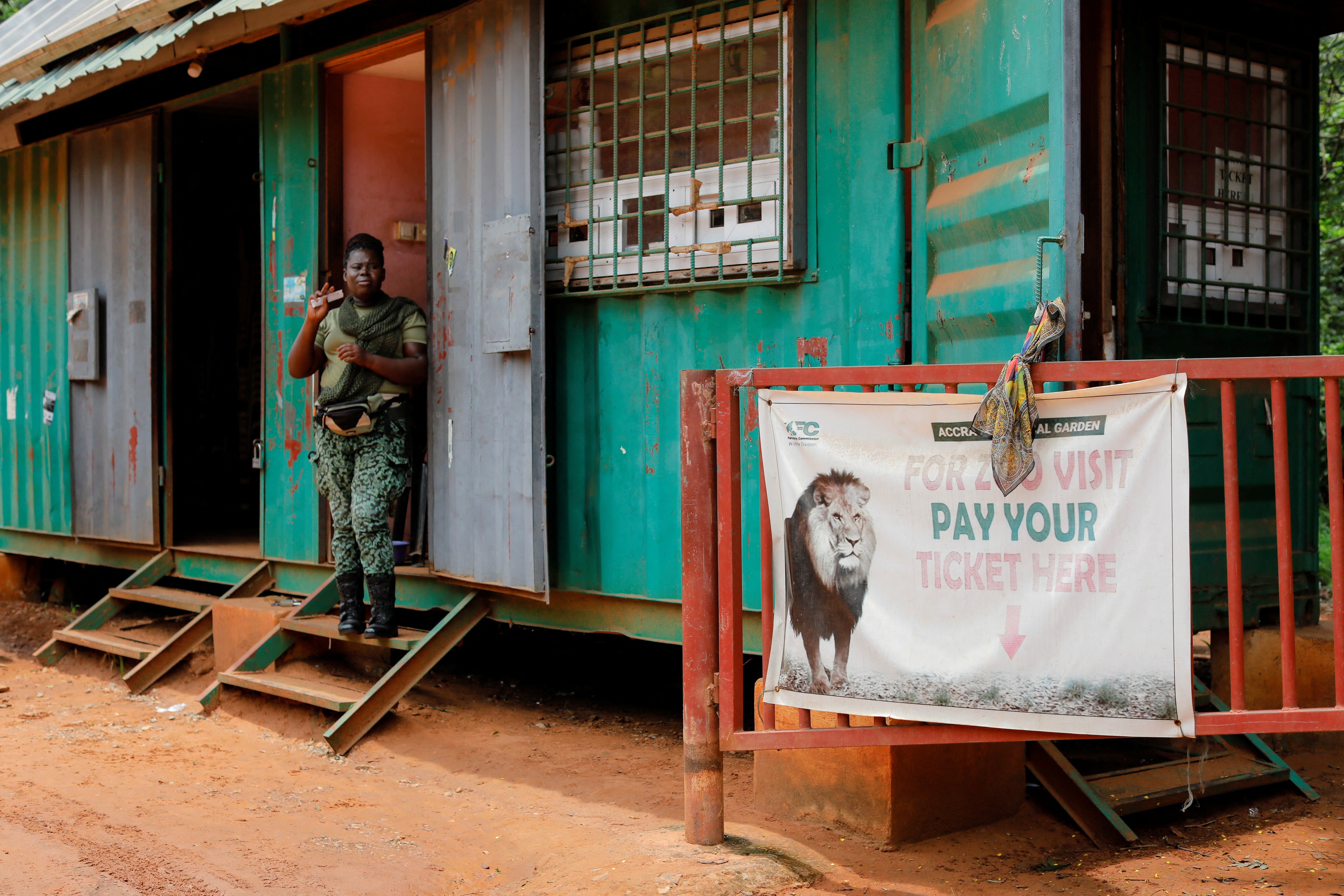 A female warden guards the entrance of the Accra Zoo a day after a lion attack