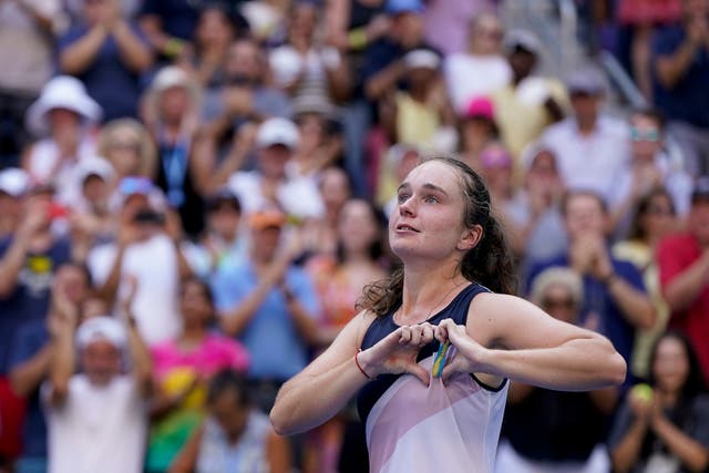 Daria Snigur makes a heart shape around the Ukraine ribbon on her chest after beating Simona Halep (Seth Wenig/AP)