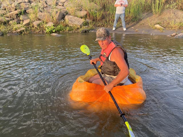 <p>A man floats down the Missouri River in a giant hollowed out pumpkin, in Bellevue, Nebraska</p>