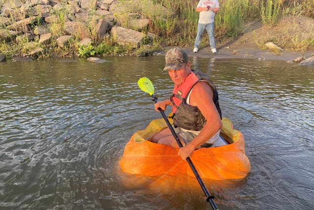 <p>A man floats down the Missouri River in a giant hollowed out pumpkin, in Bellevue, Nebraska</p>